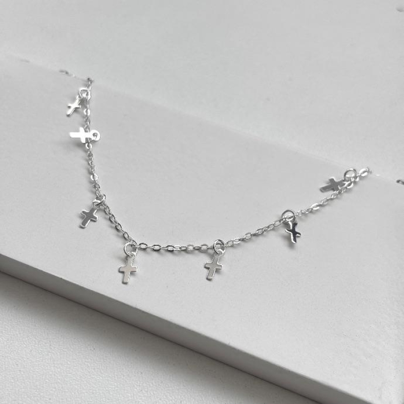 Tornozeleira com cruzes penduradas